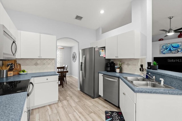 25 Round Mill Ln, Palm Coast, FL 32164 - kitchen with stainless steel appliances, arched walkways, white cabinetry, backsplash, and recessed lighting