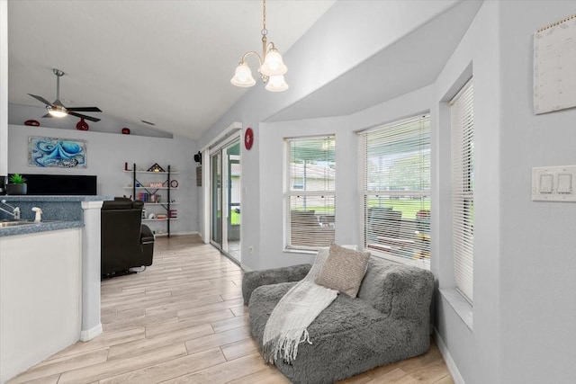 25 Round Mill Ln, Palm Coast, FL 32164 - living area with vaulted ceiling, light wood finished floors, a chandelier, and a ceiling fan