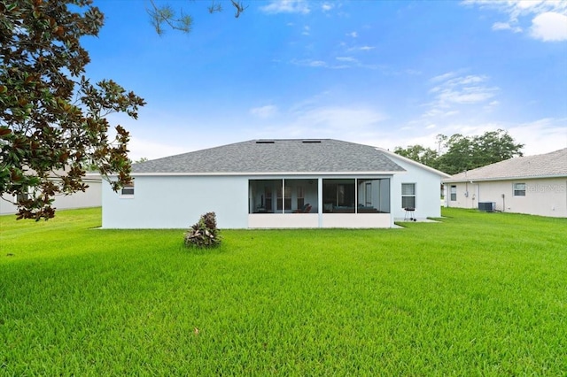 25 Round Mill Ln, Palm Coast, FL 32164 - back of house featuring a lawn, a sunroom, stucco siding, and a shingled roof