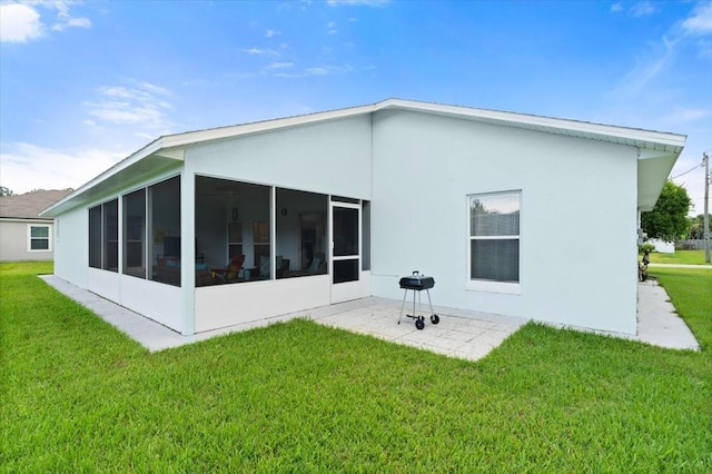 25 Round Mill Ln, Palm Coast, FL 32164 - back of house with a sunroom, a lawn, a patio area, and stucco siding