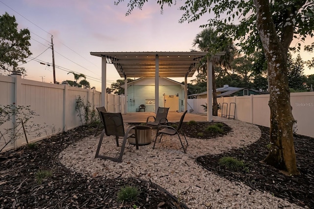 1146 Riverside Dr, Daytona Beach, FL 32117 - patio terrace at dusk with a fenced backyard, an outbuilding, and outdoor dining space