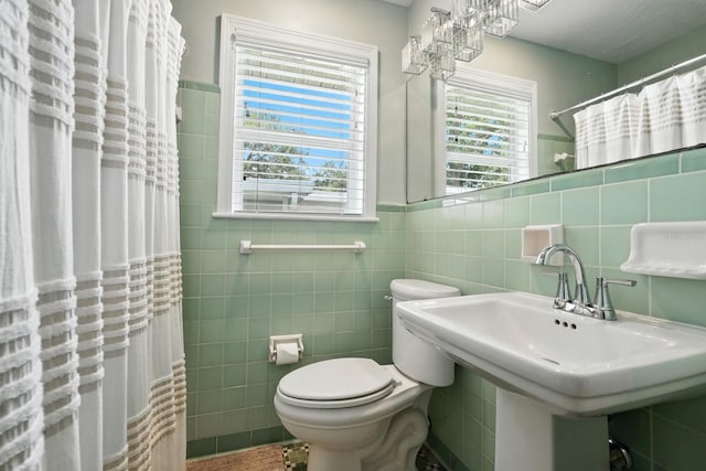 1146 Riverside Dr, Daytona Beach, FL 32117 - full bathroom with tile walls, plenty of natural light, curtained shower, and a wainscoted wall