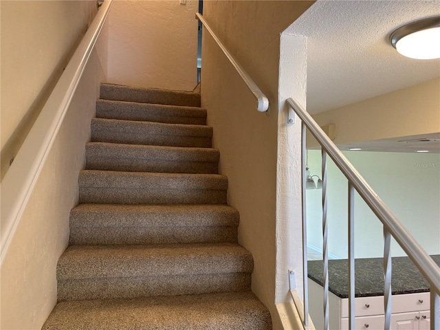 32 S Ocean Palm Villa Dr S Unit 320, Flagler Beach, FL 32136 - staircase featuring a textured ceiling