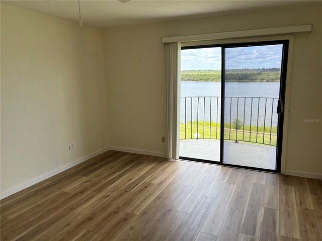 32 S Ocean Palm Villa Dr S Unit 320, Flagler Beach, FL 32136 - empty room featuring a water view, wood finished floors, and plenty of natural light