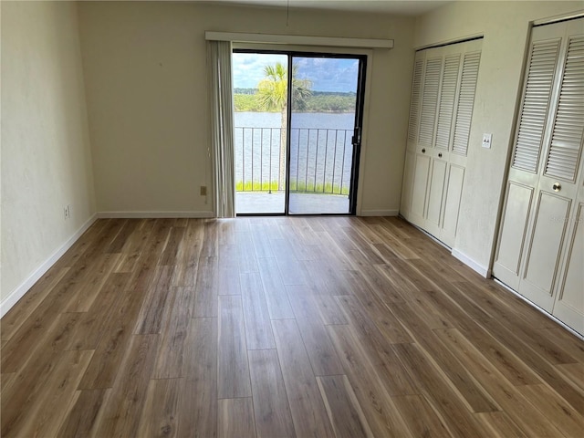 32 S Ocean Palm Villa Dr S Unit 320, Flagler Beach, FL 32136 - unfurnished bedroom with access to outside, wood finished floors, a water view, and multiple closets
