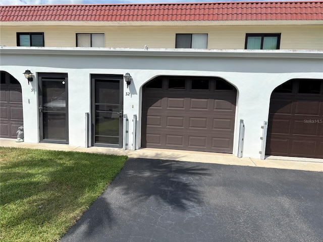 32 S Ocean Palm Villa Dr S Unit 320, Flagler Beach, FL 32136 - view of front of home featuring a tile roof, driveway, stucco siding, and a garage