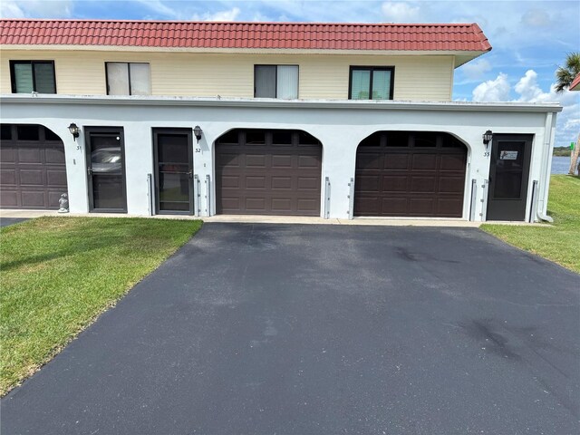 32 S Ocean Palm Villa Dr S Unit 320, Flagler Beach, FL 32136 - view of front of home with driveway, a tile roof, and a front lawn
