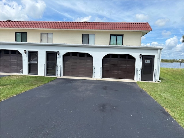 32 S Ocean Palm Villa Dr S Unit 320, Flagler Beach, FL 32136 - view of front facade featuring a tiled roof, asphalt driveway, and a front lawn