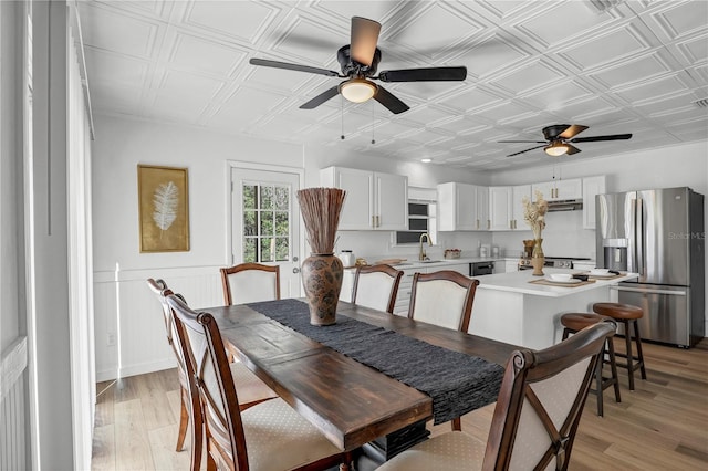 54221 Cravey Rd, Callahan, FL 32011 - dining room featuring ceiling fan, an ornate ceiling, light wood finished floors, and a wainscoted wall