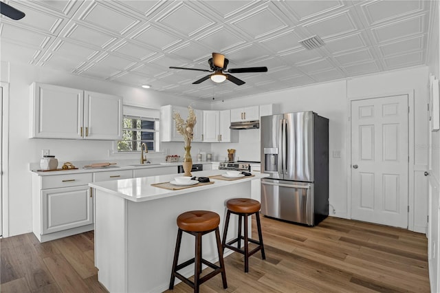 54221 Cravey Rd, Callahan, FL 32011 - kitchen featuring stainless steel appliances, an ornate ceiling, ceiling fan, light wood-style floors, and white cabinetry