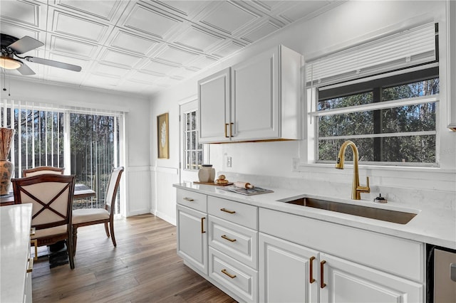 54221 Cravey Rd, Callahan, FL 32011 - kitchen featuring a ceiling fan, an ornate ceiling, light countertops, white cabinets, and a wainscoted wall