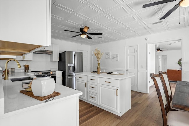 54221 Cravey Rd, Callahan, FL 32011 - kitchen with ceiling fan, stainless steel appliances, an ornate ceiling, white cabinets, and under cabinet range hood