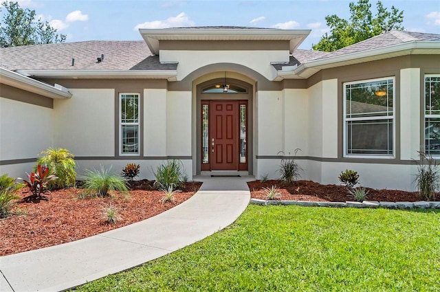 15 Long Pl, Palm Coast, FL 32137 - doorway to property featuring a yard, stucco siding, and roof with shingles