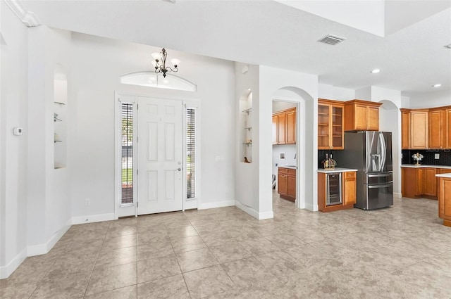 15 Long Pl, Palm Coast, FL 32137 - entryway featuring arched walkways, recessed lighting, a chandelier, wine cooler, and light tile patterned floors