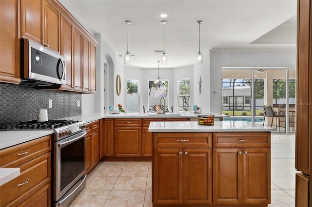 15 Long Pl, Palm Coast, FL 32137 - kitchen featuring stainless steel appliances, brown cabinetry, light tile patterned floors, and decorative backsplash