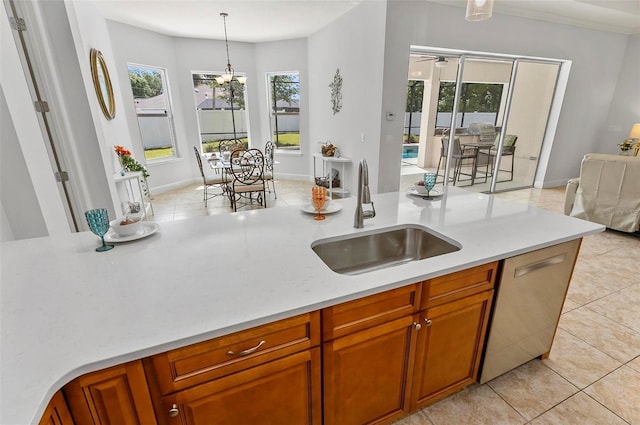 15 Long Pl, Palm Coast, FL 32137 - kitchen featuring light countertops, light tile patterned floors, stainless steel dishwasher, brown cabinets, and hanging light fixtures