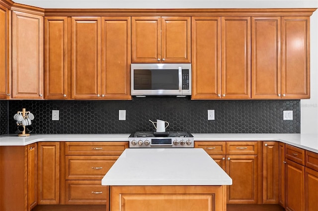 15 Long Pl, Palm Coast, FL 32137 - kitchen with stainless steel appliances, a center island, light countertops, and brown cabinetry