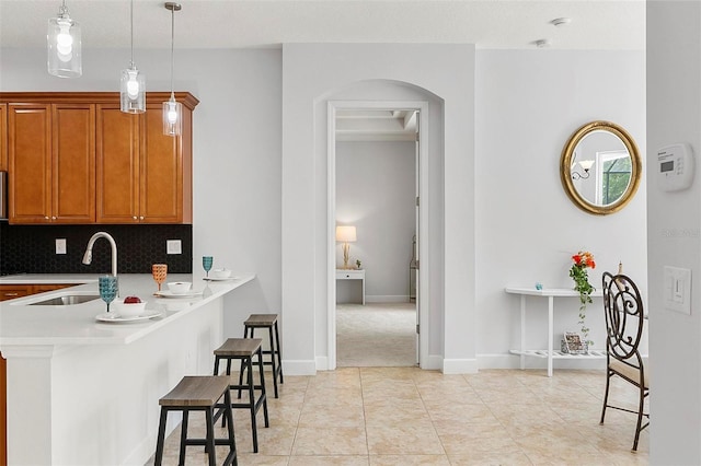 15 Long Pl, Palm Coast, FL 32137 - kitchen with a breakfast bar, light countertops, arched walkways, backsplash, and brown cabinets