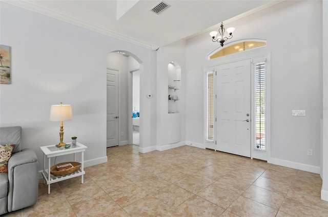 15 Long Pl, Palm Coast, FL 32137 - entrance foyer featuring crown molding, arched walkways, healthy amount of natural light, light tile patterned floors, and a chandelier