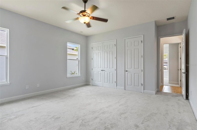 15 Long Pl, Palm Coast, FL 32137 - unfurnished bedroom with carpet floors, multiple closets, and a ceiling fan