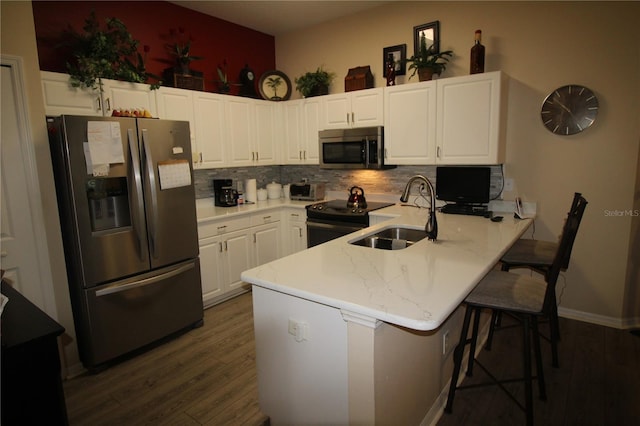 07 Gaston Pl, Palm Coast, FL 32164 - kitchen with stainless steel appliances, a peninsula, dark wood-type flooring, and backsplash