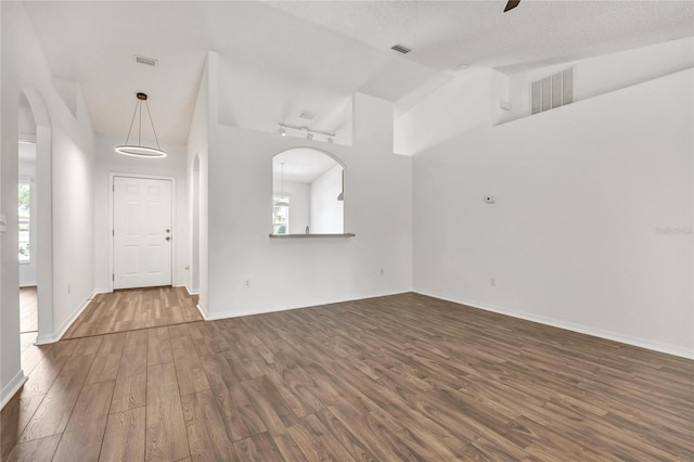 112 Ulaturn Trl, Palm Coast, FL 32164 - unfurnished living room featuring wood finished floors, high vaulted ceiling, a ceiling fan, and arched walkways