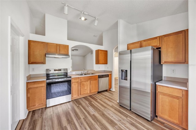 112 Ulaturn Trl, Palm Coast, FL 32164 - kitchen featuring appliances with stainless steel finishes, under cabinet range hood, arched walkways, light wood finished floors, and light countertops
