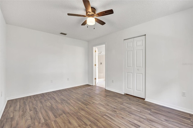 112 Ulaturn Trl, Palm Coast, FL 32164 - unfurnished bedroom with a textured ceiling, wood finished floors, a closet, ensuite bathroom, and ceiling fan