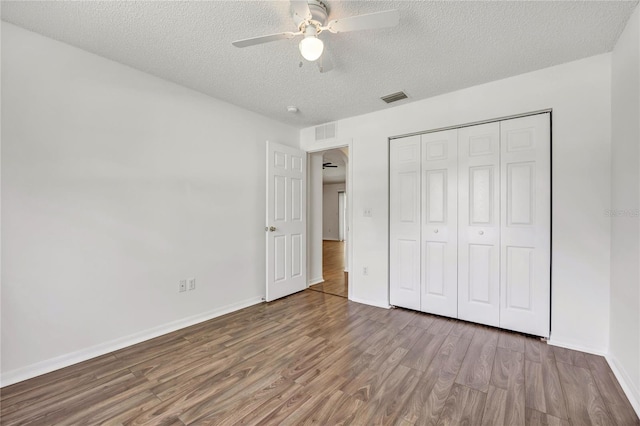 112 Ulaturn Trl, Palm Coast, FL 32164 - unfurnished bedroom featuring wood finished floors, a textured ceiling, a closet, and a ceiling fan