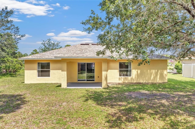 112 Ulaturn Trl, Palm Coast, FL 32164 - rear view of house featuring stucco siding, roof with shingles, a yard, and a patio