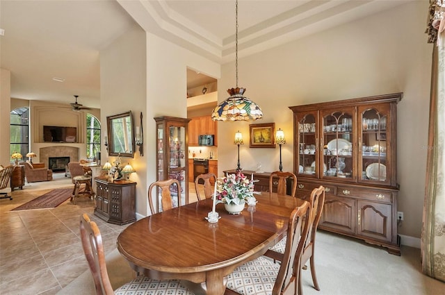 23 Creekside Dr, Palm Coast, FL 32137 - dining area with a high ceiling, a glass covered fireplace, a ceiling fan, and light tile patterned flooring