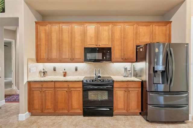 23 Creekside Dr, Palm Coast, FL 32137 - kitchen with black appliances, light stone countertops, tasteful backsplash, and brown cabinetry