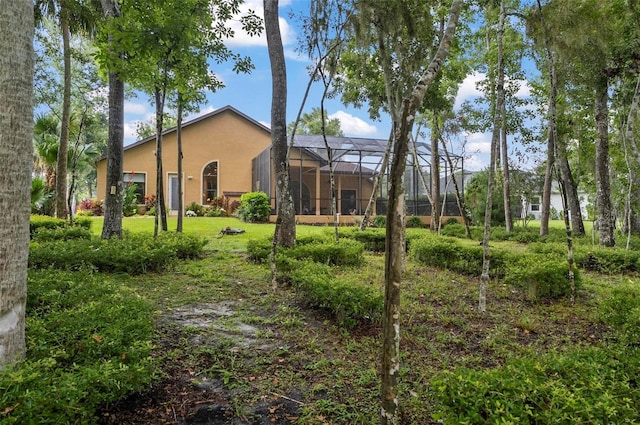 23 Creekside Dr, Palm Coast, FL 32137 - back of property with stucco siding, glass enclosure, and a lawn