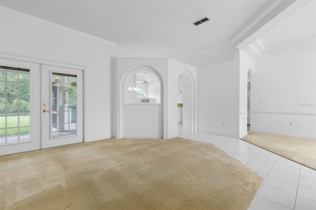16 Birchwood Pl, Palm Coast, FL 32137 - carpeted spare room featuring tile patterned floors, arched walkways, and french doors