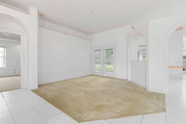 16 Birchwood Pl, Palm Coast, FL 32137 - carpeted empty room with arched walkways, tile patterned flooring, and french doors