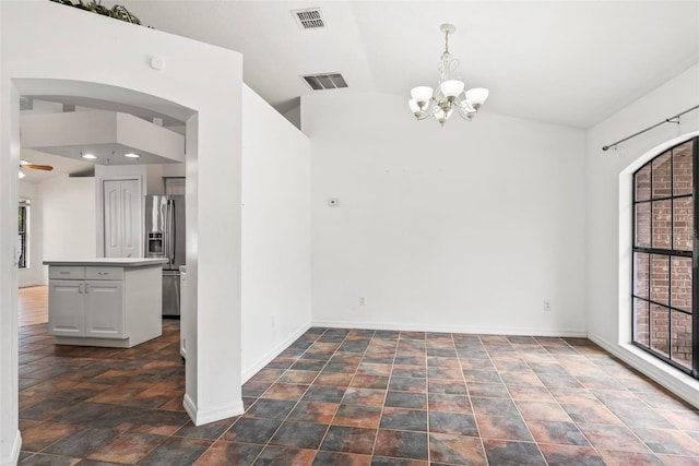 2790 Pelham Cir, Deltona, FL 32738 - unfurnished dining area with a chandelier, lofted ceiling, arched walkways, and stone finish flooring
