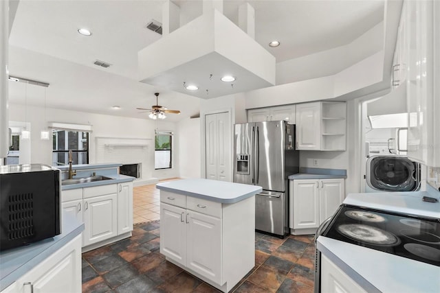2790 Pelham Cir, Deltona, FL 32738 - kitchen with stainless steel fridge with ice dispenser, ceiling fan, range with electric cooktop, a fireplace with raised hearth, and light countertops
