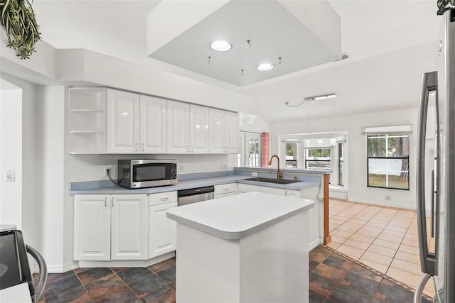 2790 Pelham Cir, Deltona, FL 32738 - kitchen with stainless steel appliances, a peninsula, a raised ceiling, white cabinetry, and light countertops