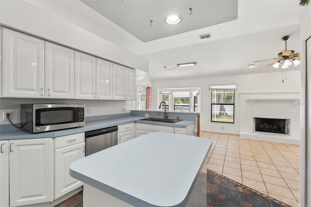 2790 Pelham Cir, Deltona, FL 32738 - kitchen featuring stainless steel appliances, a peninsula, white cabinets, ceiling fan, and healthy amount of natural light