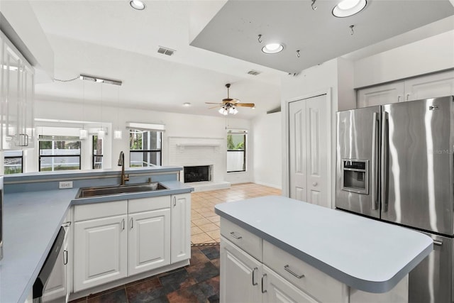 2790 Pelham Cir, Deltona, FL 32738 - kitchen with stainless steel fridge with ice dispenser, ceiling fan, a fireplace, dishwashing machine, and white cabinets