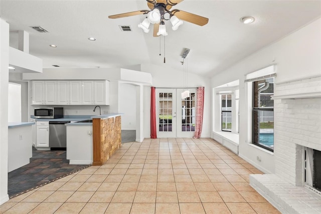 2790 Pelham Cir, Deltona, FL 32738 - kitchen with stainless steel appliances, white cabinets, ceiling fan, vaulted ceiling, and a peninsula