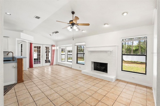 2790 Pelham Cir, Deltona, FL 32738 - unfurnished living room with light tile patterned floors, vaulted ceiling, a ceiling fan, a fireplace, and french doors