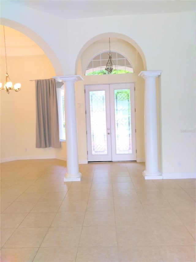 28 Front St, Palm Coast, FL 32137 - foyer entrance with a chandelier, light tile patterned floors, ornate columns, french doors, and arched walkways