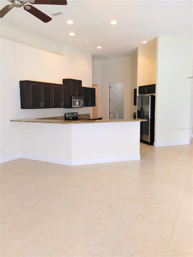 28 Front St, Palm Coast, FL 32137 - kitchen featuring freestanding refrigerator, recessed lighting, light stone countertops, a ceiling fan, and stainless steel microwave