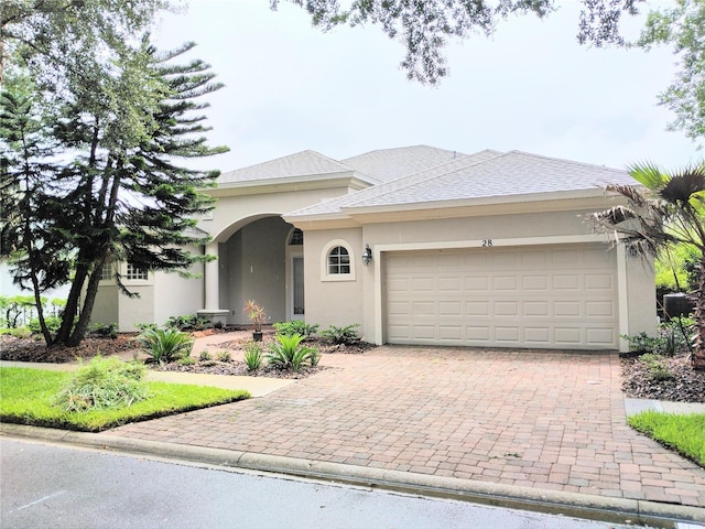 28 Front St, Palm Coast, FL 32137 - view of front facade with decorative driveway, a garage, and stucco siding