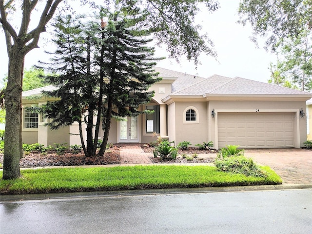 28 Front St, Palm Coast, FL 32137 - view of front of home featuring french doors, stucco siding, an attached garage, and driveway