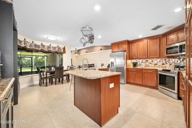 3959 S Chinook Ln, Ormond Beach, FL 32174 - kitchen with stainless steel appliances, tasteful backsplash, brown cabinets, light tile patterned floors, and recessed lighting