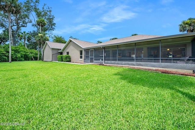 3959 S Chinook Ln, Ormond Beach, FL 32174 - back of house with a sunroom, a lawn, and stucco siding