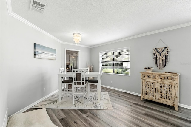 16 Courtney Pl, Palm Coast, FL 32137 - dining area with crown molding, a textured ceiling, wood finished floors, and a chandelier