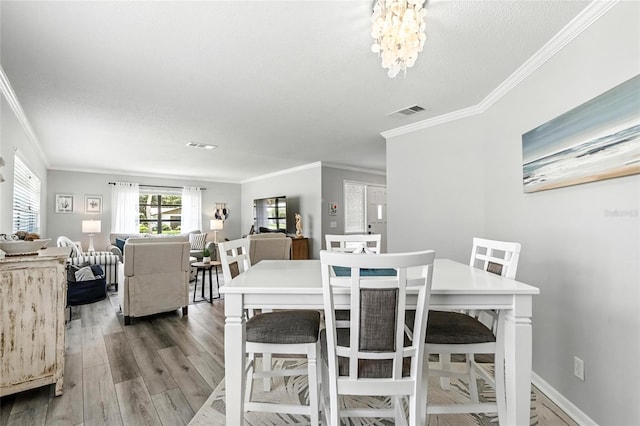 16 Courtney Pl, Palm Coast, FL 32137 - dining room featuring ornamental molding, wood finished floors, a chandelier, and a textured ceiling